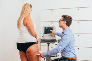 Facharzt Dr. Sauter von LIPOCURA® untersucht die Fettgewebsdicke eine Lipödem-Patientin via Ultraschall